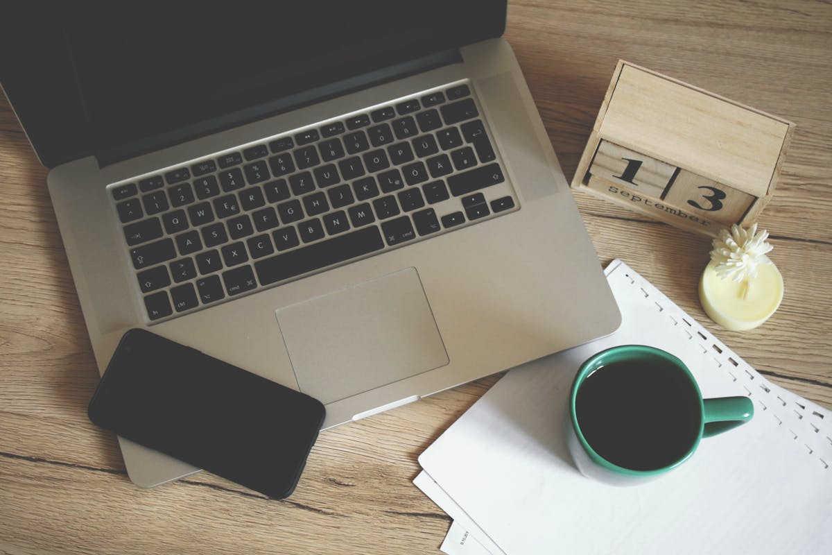 Scrivania con laptop, smartphone e tazza di caffè